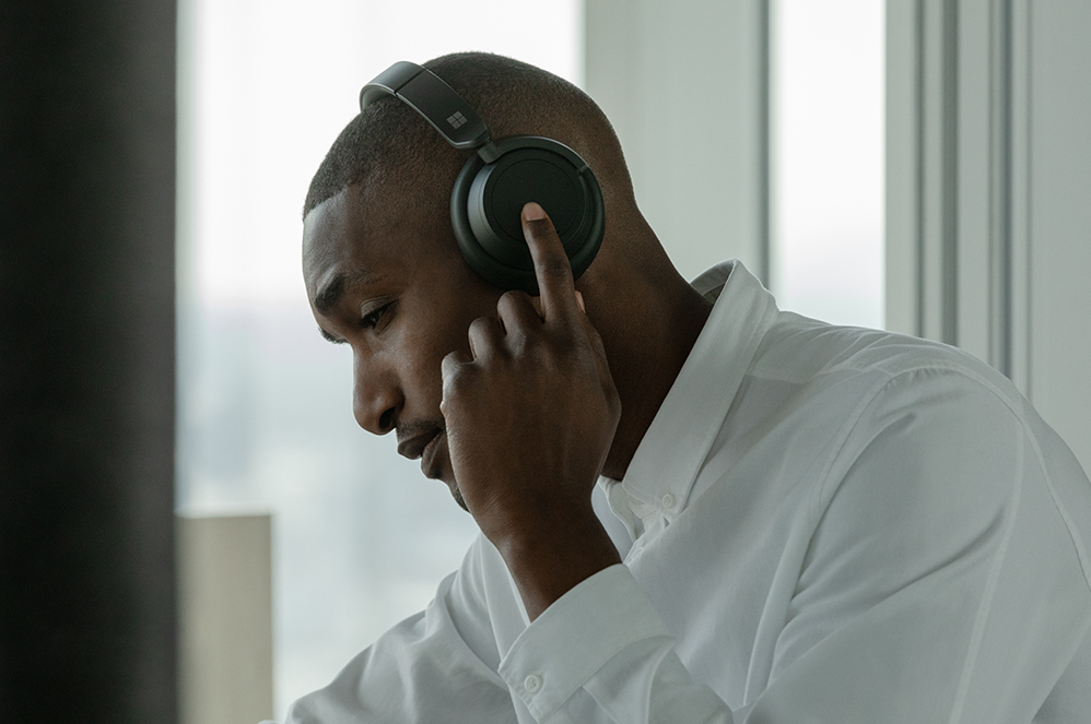 佩戴 Surface Headphones 2+ 的使用者，在一侧耳罩上进行触控操作。 